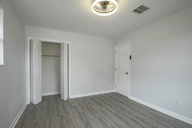 unfurnished bedroom with hardwood / wood-style floors and a closet