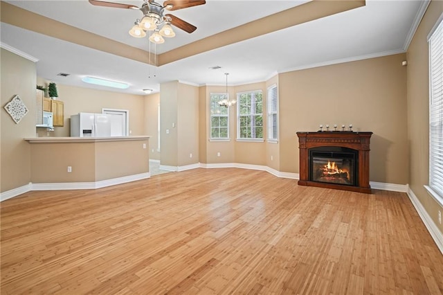 unfurnished living room with ceiling fan with notable chandelier, ornamental molding, and light hardwood / wood-style flooring