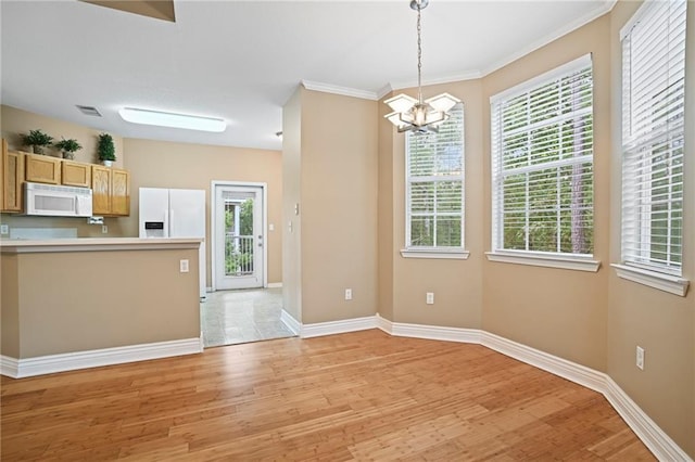 kitchen with light wood-type flooring, pendant lighting, crown molding, white appliances, and a chandelier