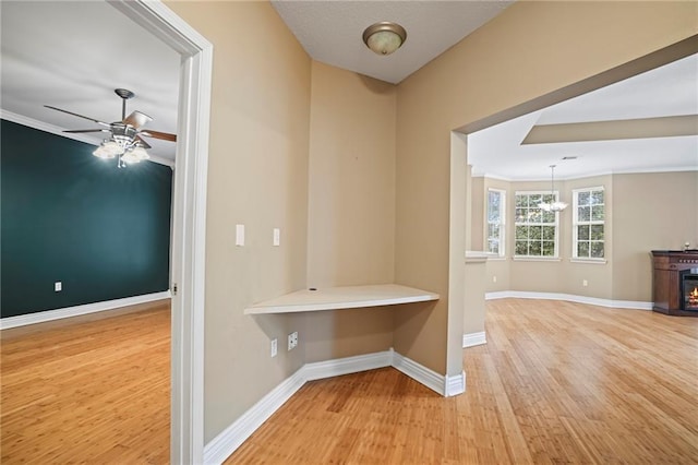 corridor featuring crown molding, an inviting chandelier, and hardwood / wood-style flooring