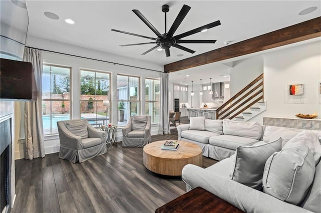 living room with ceiling fan, dark hardwood / wood-style floors, a high end fireplace, and a healthy amount of sunlight