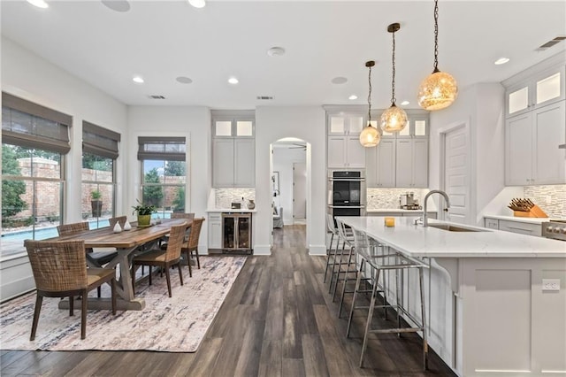 kitchen featuring sink, wine cooler, dark hardwood / wood-style flooring, and tasteful backsplash