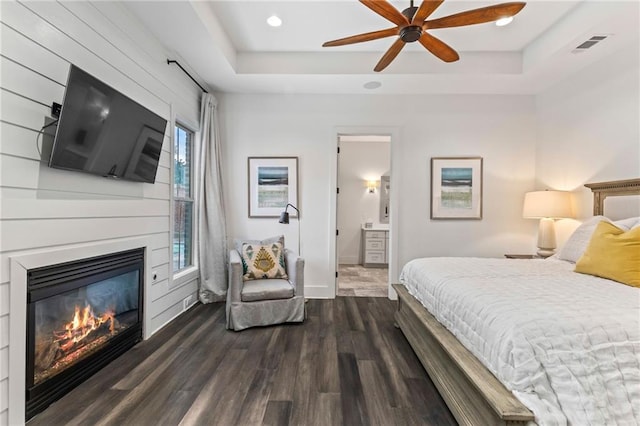 bedroom with multiple windows, dark hardwood / wood-style flooring, ensuite bathroom, and ceiling fan