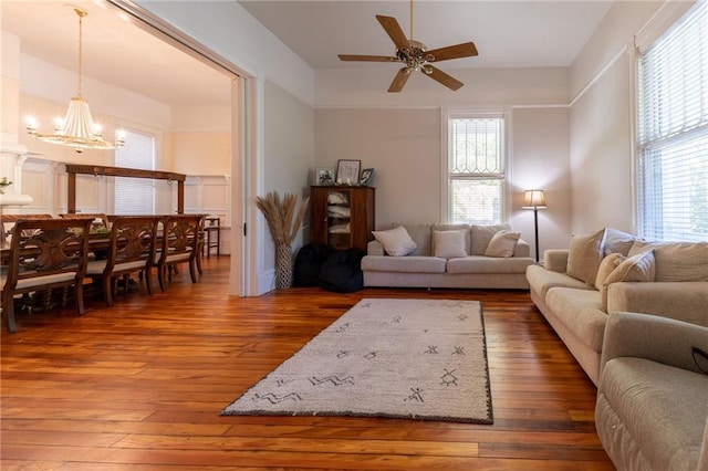 living room featuring ceiling fan with notable chandelier, plenty of natural light, and dark hardwood / wood-style floors