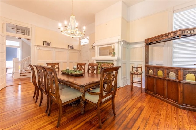 dining space featuring hardwood / wood-style flooring, an inviting chandelier, and a high ceiling