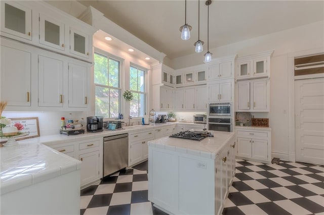 kitchen with appliances with stainless steel finishes, white cabinetry, and a kitchen island