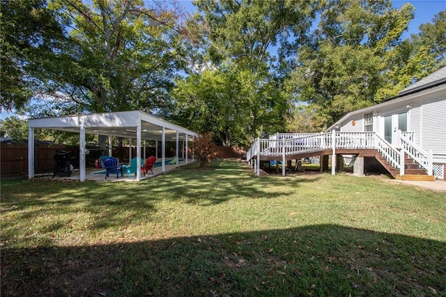 view of yard featuring a wooden deck and a patio