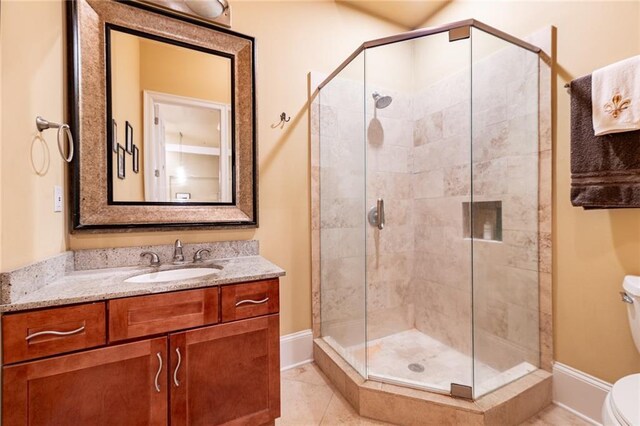 bathroom with vanity, toilet, walk in shower, and tile patterned flooring