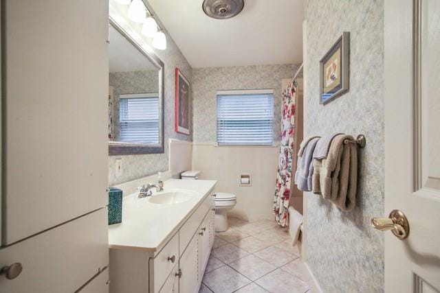 full bathroom featuring vanity, toilet, tile patterned flooring, and shower / bathtub combination with curtain