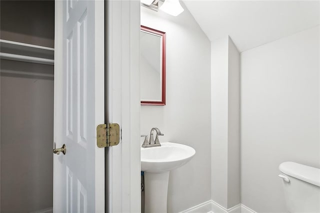 bathroom featuring lofted ceiling and toilet