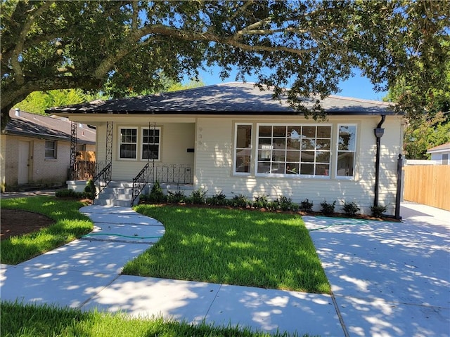 view of front of property with a front yard and fence