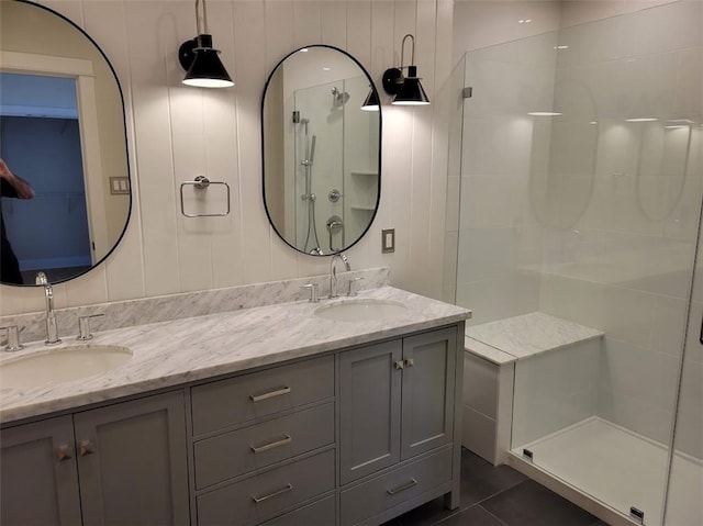 full bathroom with a shower stall, double vanity, tile patterned floors, and a sink