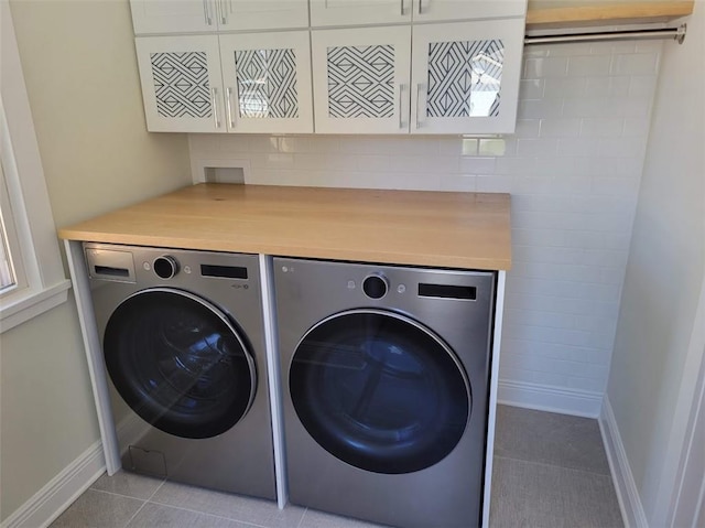 washroom featuring light tile patterned floors, independent washer and dryer, and cabinet space