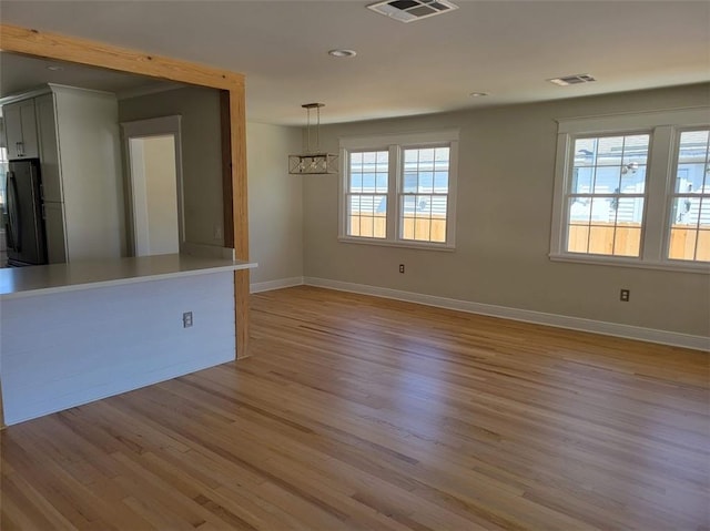 empty room featuring visible vents, recessed lighting, baseboards, and light wood-style floors