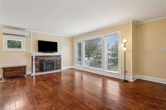 unfurnished living room featuring ornamental molding, a wall mounted air conditioner, a fireplace, and hardwood / wood-style floors