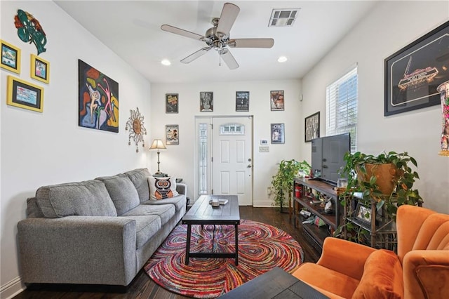 living room featuring dark wood-type flooring and ceiling fan