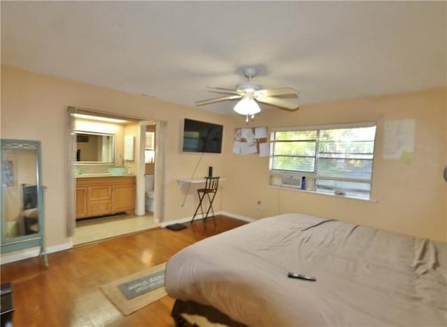 bedroom featuring ensuite bath, ceiling fan, and hardwood / wood-style flooring