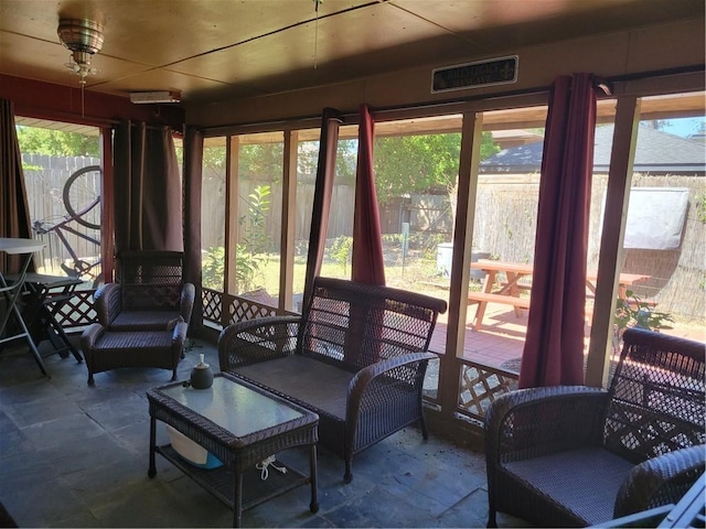 sunroom featuring ceiling fan and a wealth of natural light