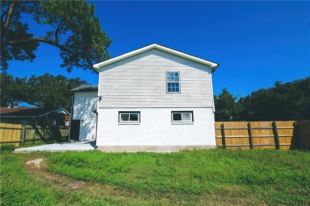 view of side of property featuring a yard and a patio