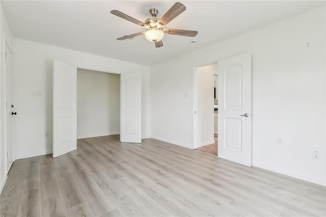 unfurnished bedroom with ceiling fan, a closet, and light wood-type flooring