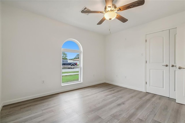 spare room with light wood-type flooring and ceiling fan