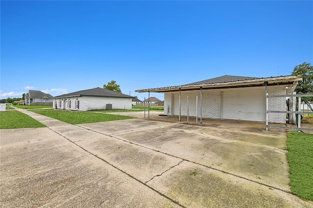 view of side of home with a yard, a garage, and a carport