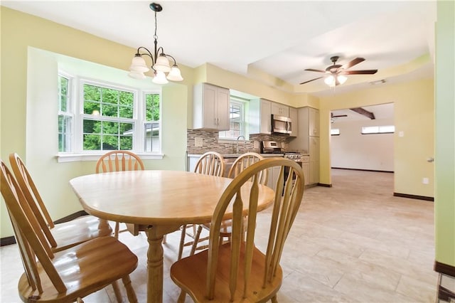 dining space featuring ceiling fan with notable chandelier