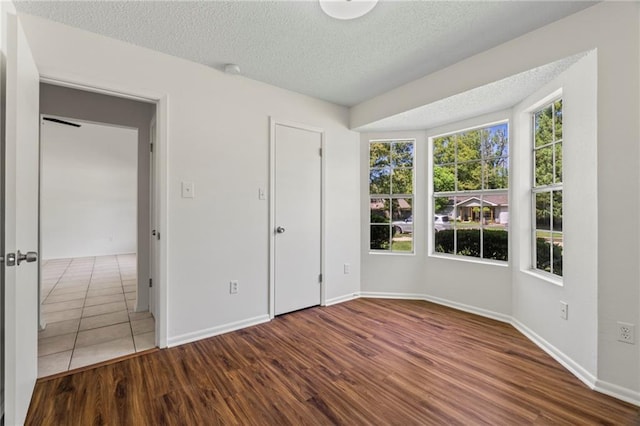 unfurnished bedroom featuring wood-type flooring and a textured ceiling