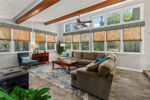 sunroom / solarium featuring ceiling fan and lofted ceiling with beams