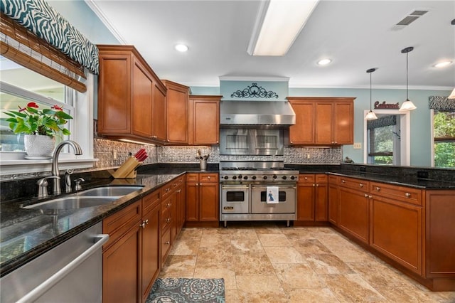 kitchen featuring dark stone countertops, crown molding, decorative light fixtures, sink, and appliances with stainless steel finishes