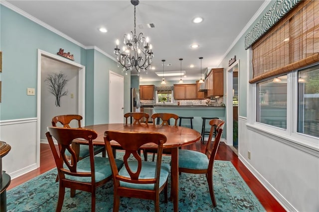 dining space with ornamental molding, dark wood-type flooring, and a notable chandelier