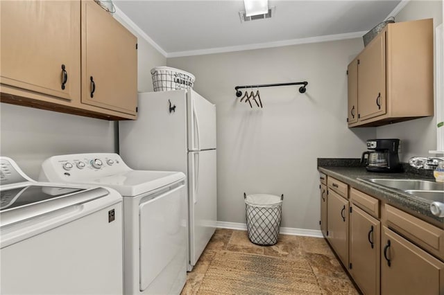 clothes washing area with ornamental molding, washing machine and dryer, and sink