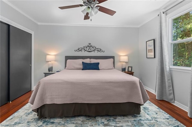 bedroom with dark wood-type flooring, ceiling fan, and ornamental molding