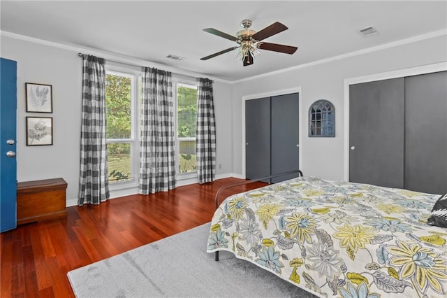 bedroom with dark wood-type flooring, ceiling fan, ornamental molding, and a closet