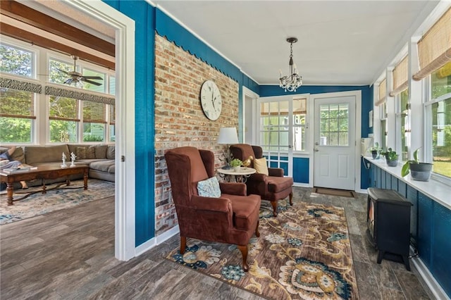 sunroom featuring vaulted ceiling and ceiling fan with notable chandelier