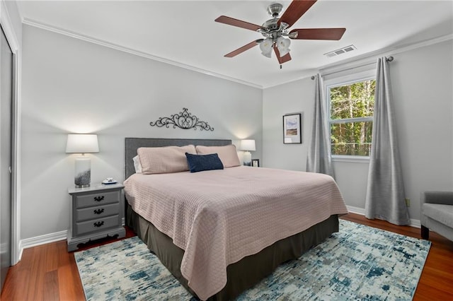 bedroom with crown molding, dark hardwood / wood-style flooring, and ceiling fan