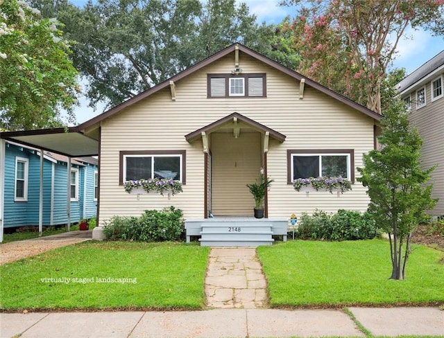 bungalow-style house with a front lawn and a carport