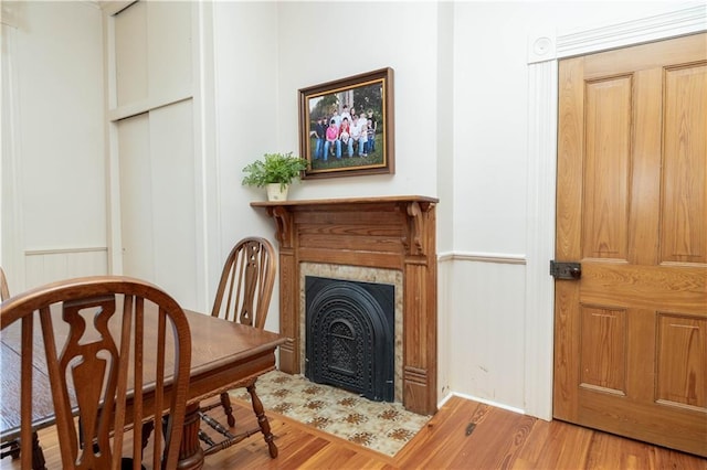 dining area with a fireplace with flush hearth and wood finished floors