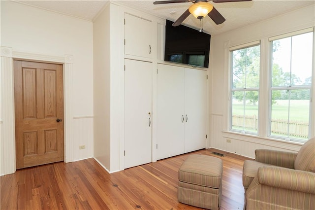 unfurnished room with visible vents, a textured ceiling, ceiling fan, and light wood finished floors