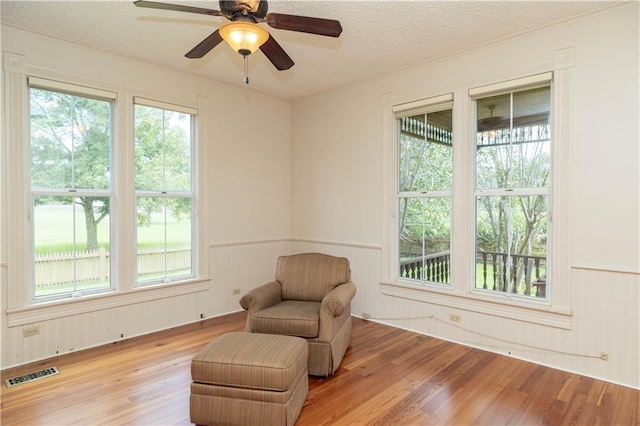 sitting room with a wealth of natural light, visible vents, and light wood-style floors