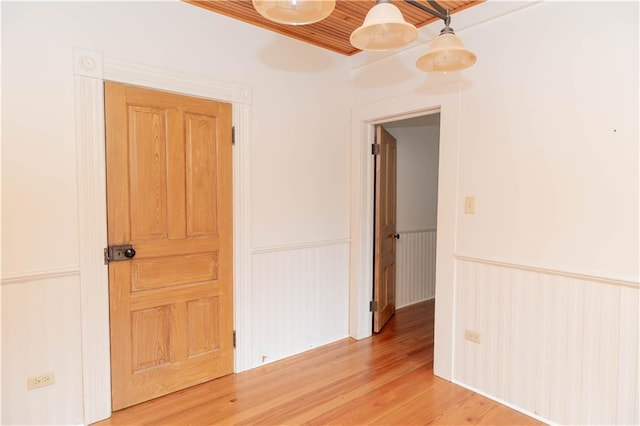 unfurnished room with a wainscoted wall and light wood finished floors