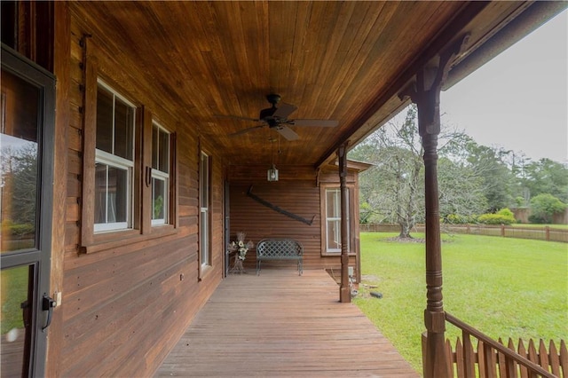 wooden deck with a lawn, a ceiling fan, and fence