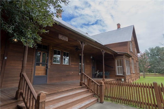 wooden terrace featuring a porch and fence