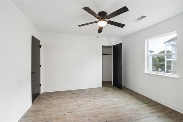 unfurnished bedroom with ceiling fan, a closet, and light hardwood / wood-style floors