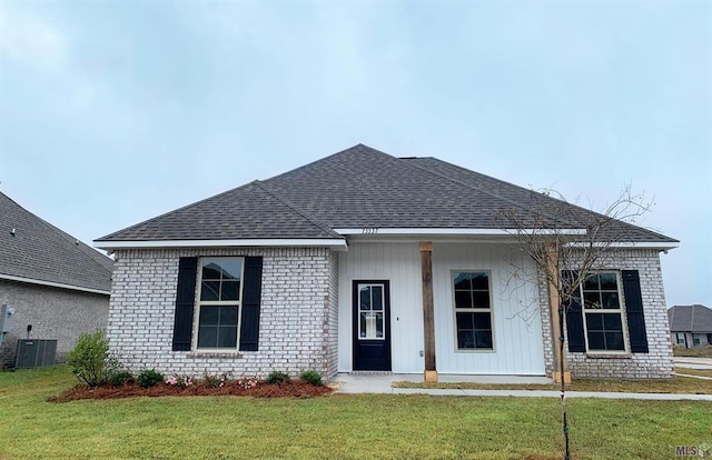 view of front facade featuring cooling unit and a front yard