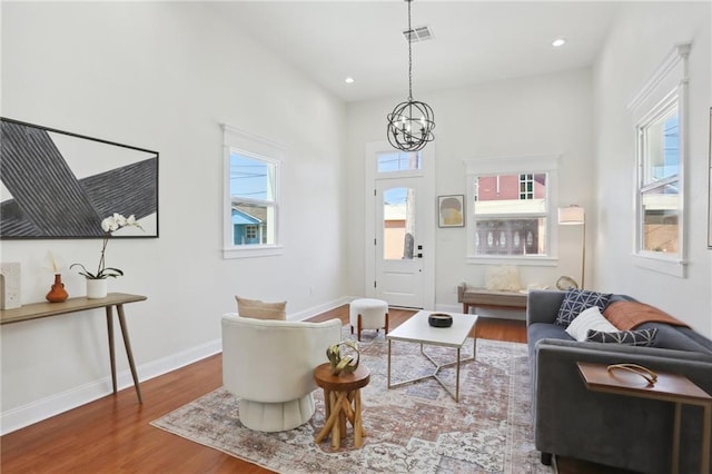 living room featuring wood-type flooring and a chandelier