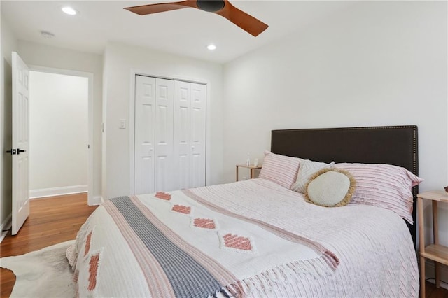 bedroom featuring hardwood / wood-style flooring, ceiling fan, and a closet