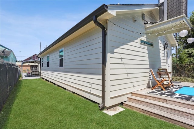 exterior space with a wooden deck and a lawn