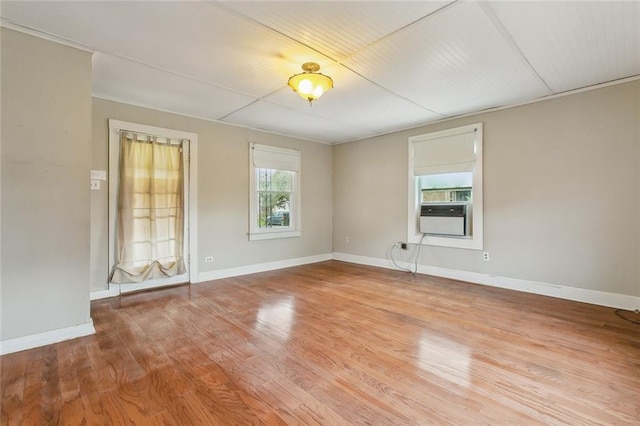 spare room featuring cooling unit and light hardwood / wood-style flooring