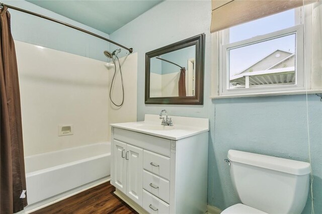 full bathroom featuring vanity, toilet, wood-type flooring, and shower / bathtub combination with curtain